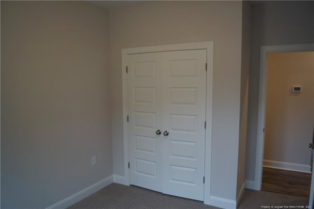 unfurnished bedroom with carpet, baseboards, and a closet