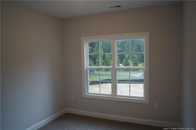 unfurnished room with visible vents, carpet, and baseboards