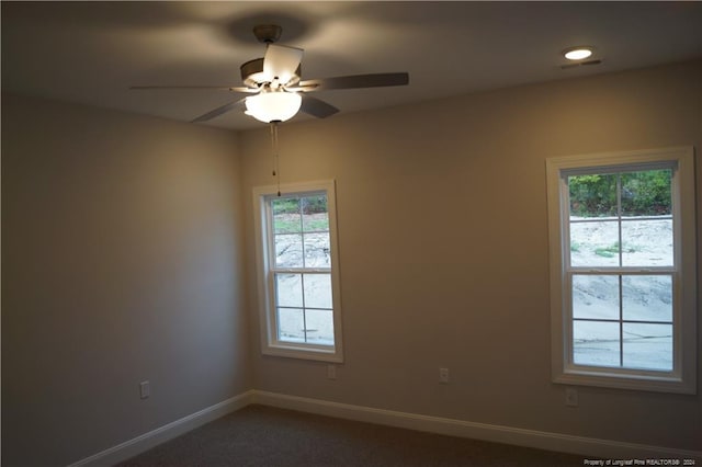 unfurnished room featuring visible vents, a healthy amount of sunlight, baseboards, and ceiling fan