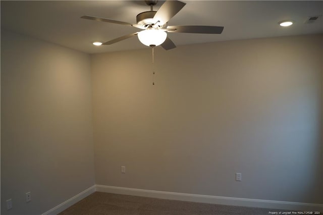 empty room featuring baseboards, visible vents, carpet floors, and ceiling fan