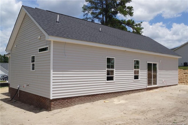 rear view of house with roof with shingles