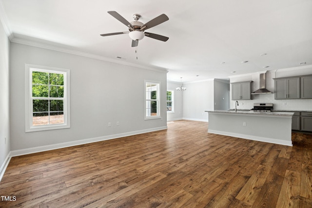 unfurnished living room with crown molding, a healthy amount of sunlight, and dark hardwood / wood-style flooring