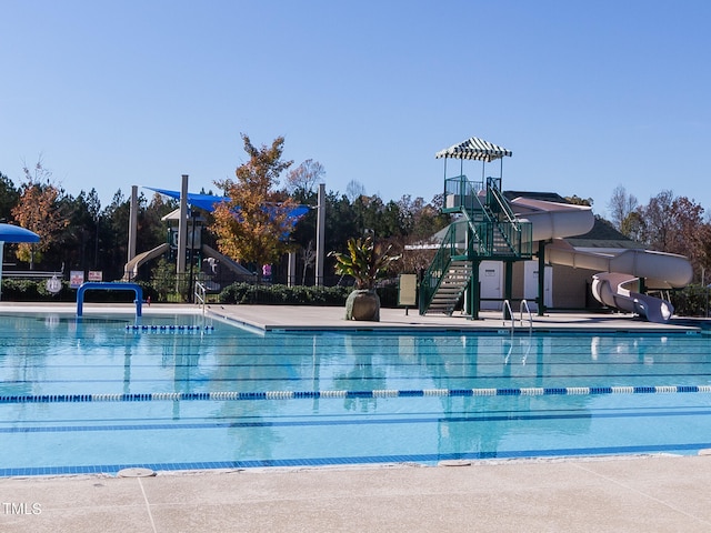 view of pool featuring a water slide and a playground