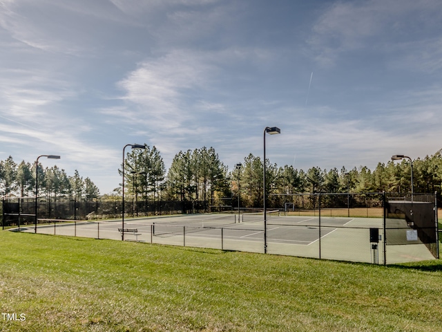 view of tennis court featuring a yard