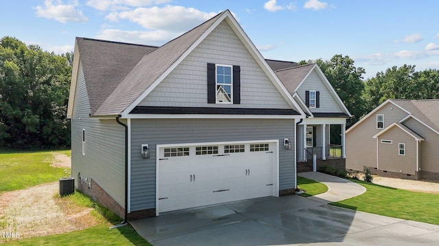 craftsman house featuring central AC unit, a garage, and a front yard