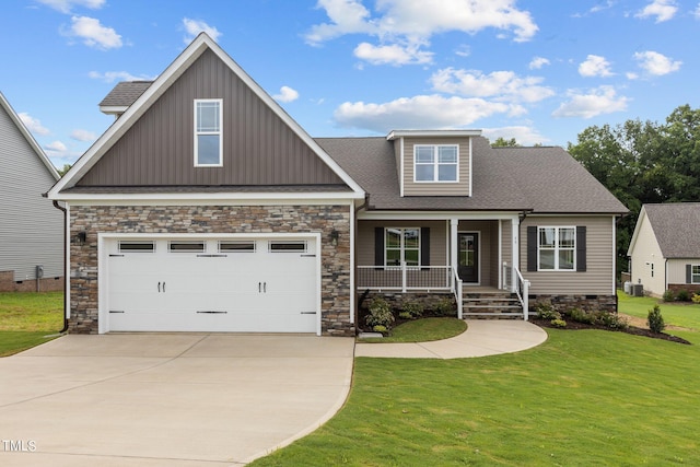 craftsman-style house with central AC unit, a garage, a front yard, and covered porch