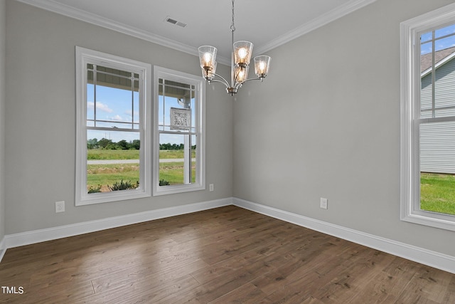 spare room with crown molding, dark wood-type flooring, and an inviting chandelier