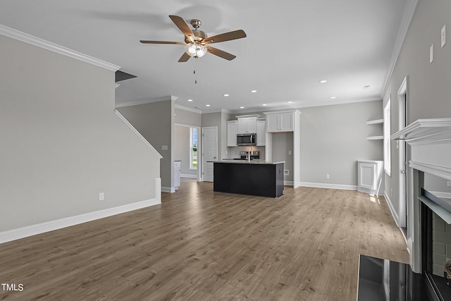 unfurnished living room featuring ceiling fan, light hardwood / wood-style flooring, and ornamental molding