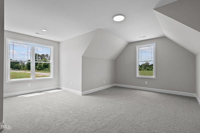 bonus room with carpet flooring, vaulted ceiling, and a healthy amount of sunlight