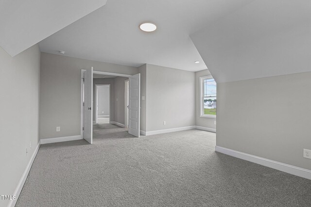 bonus room featuring lofted ceiling and light carpet