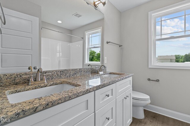 bathroom with dual vanity, wood-type flooring, and toilet