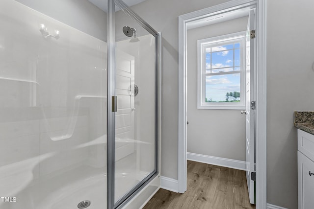 bathroom featuring walk in shower, vanity, and hardwood / wood-style floors