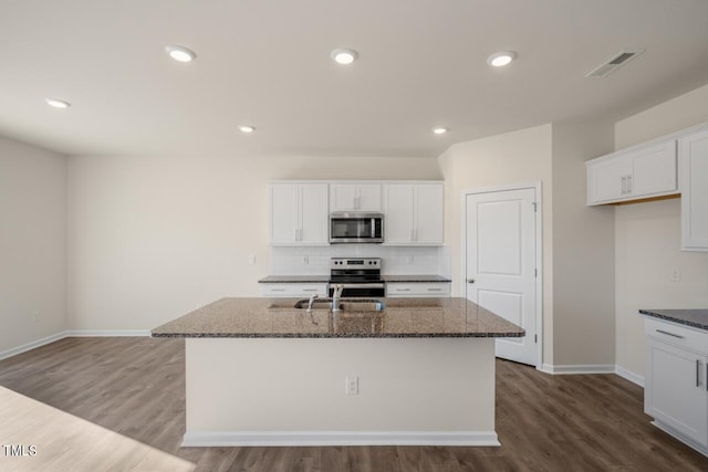 kitchen with a kitchen island with sink, stainless steel appliances, and white cabinets