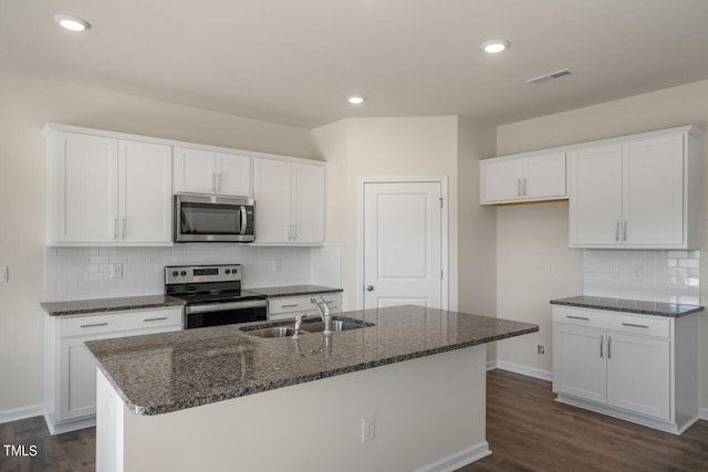 kitchen featuring white cabinets, stainless steel appliances, sink, and an island with sink