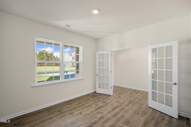 empty room featuring french doors and hardwood / wood-style floors