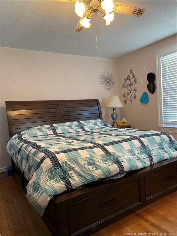 bedroom with ceiling fan and wood-type flooring