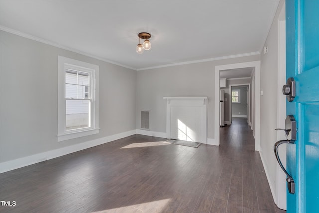 spare room with crown molding, a wealth of natural light, and dark hardwood / wood-style floors