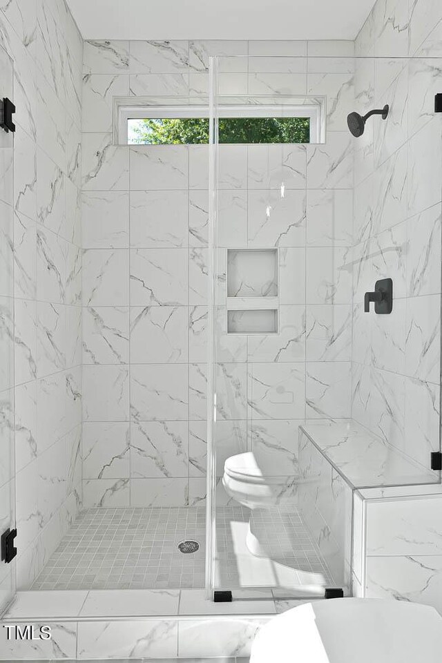 bathroom featuring an enclosed shower and toilet