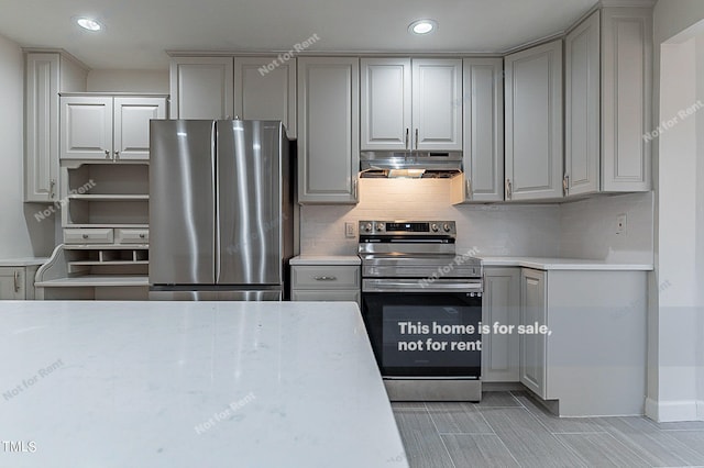 kitchen featuring stainless steel fridge, gray cabinets, range with electric cooktop, and tasteful backsplash