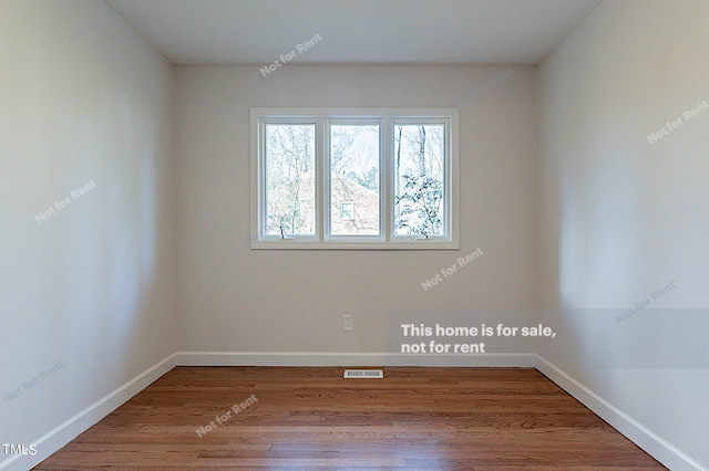 empty room with dark hardwood / wood-style flooring