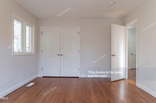 unfurnished bedroom featuring dark hardwood / wood-style flooring