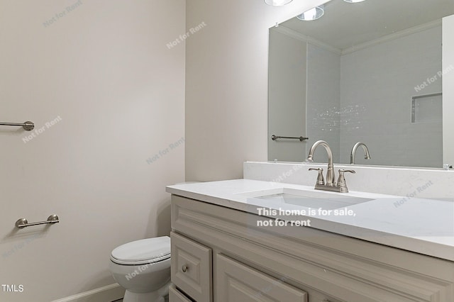 bathroom featuring toilet, ornamental molding, and oversized vanity