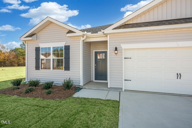 view of exterior entry featuring a yard and a garage