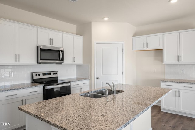 kitchen featuring dark hardwood / wood-style floors, a center island with sink, sink, white cabinets, and appliances with stainless steel finishes