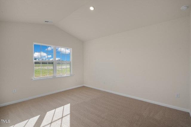 unfurnished room with light carpet and lofted ceiling