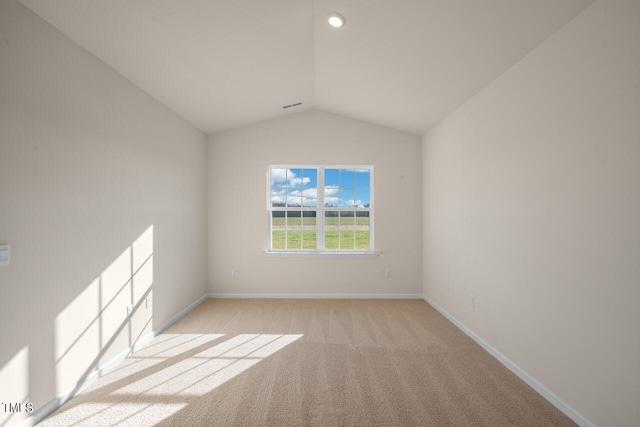 empty room with vaulted ceiling and light carpet