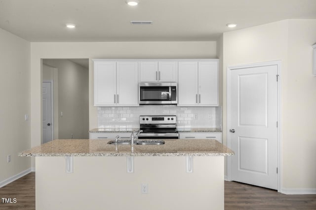 kitchen featuring white cabinetry, stainless steel appliances, sink, and an island with sink