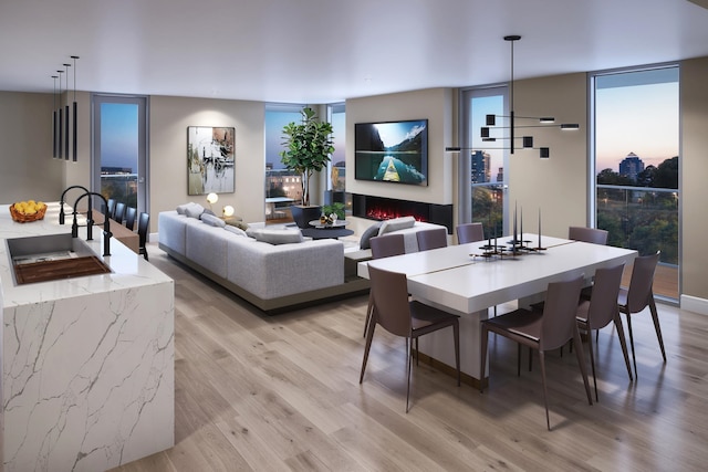 dining room with expansive windows, a chandelier, and light hardwood / wood-style flooring