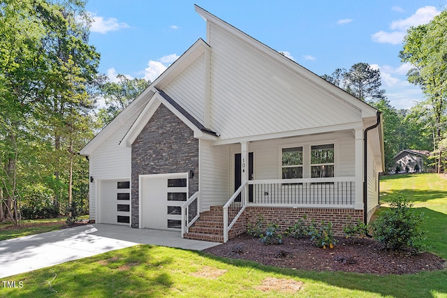 view of front of house featuring a front yard, a garage, and a porch