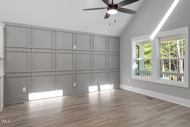 interior space featuring light hardwood / wood-style flooring, ceiling fan, and high vaulted ceiling