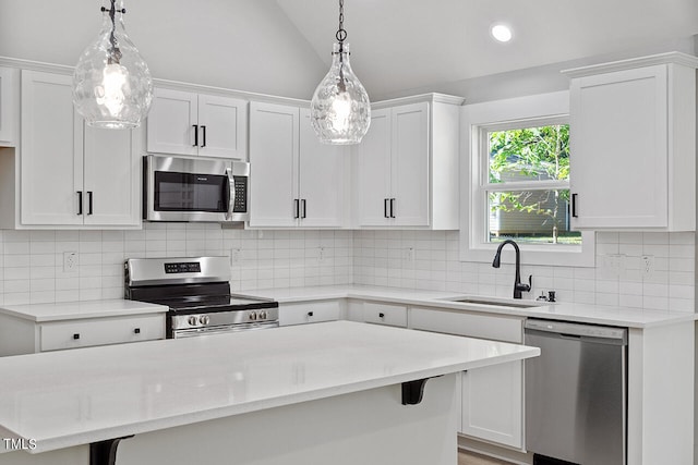 kitchen featuring hanging light fixtures, white cabinetry, sink, and stainless steel appliances