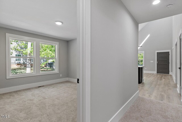 corridor featuring light colored carpet