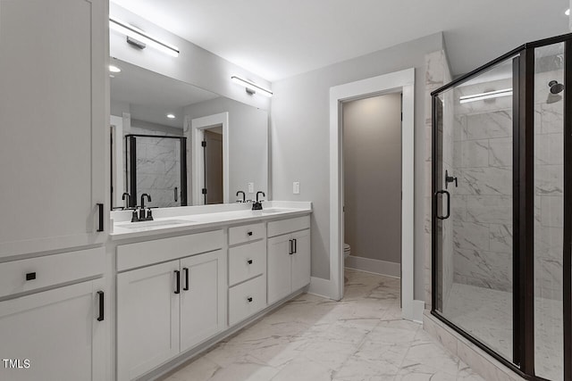 bathroom featuring vanity, a shower with shower door, and toilet