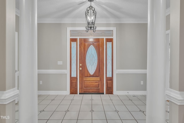 entrance foyer with ornate columns, crown molding, and a textured ceiling