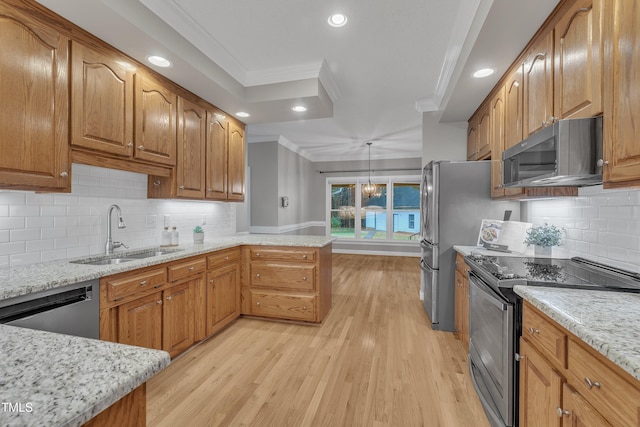 kitchen with hanging light fixtures, crown molding, sink, appliances with stainless steel finishes, and kitchen peninsula