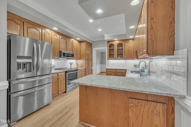 kitchen with light stone counters, kitchen peninsula, and appliances with stainless steel finishes