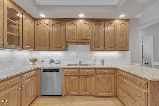 kitchen with kitchen peninsula, light stone counters, dishwasher, and sink