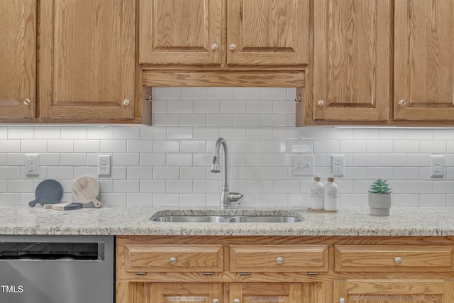 kitchen with decorative backsplash, light stone counters, dishwasher, and sink