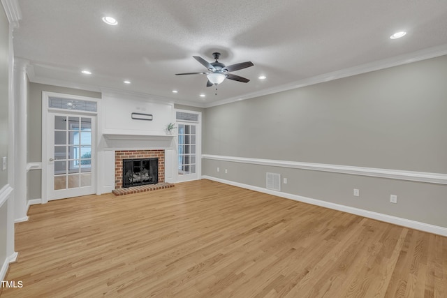 unfurnished living room featuring ornamental molding, a fireplace, and light hardwood / wood-style flooring