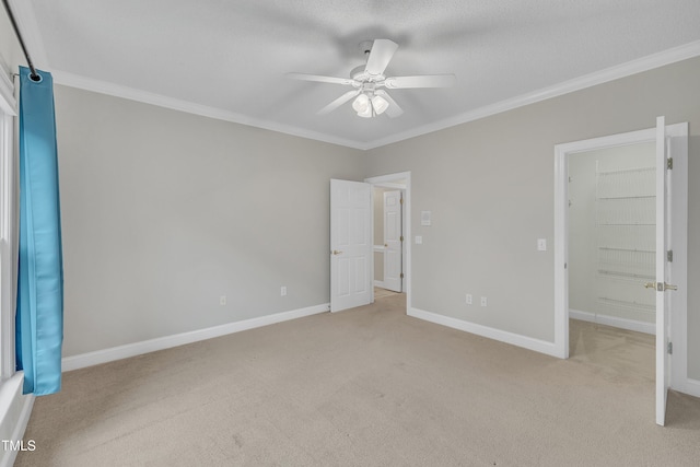 unfurnished bedroom with ceiling fan, a spacious closet, ornamental molding, light colored carpet, and a closet