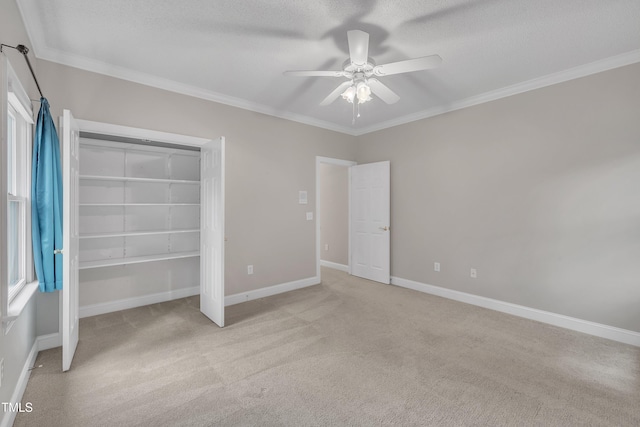 unfurnished bedroom featuring ceiling fan, a closet, light colored carpet, and ornamental molding