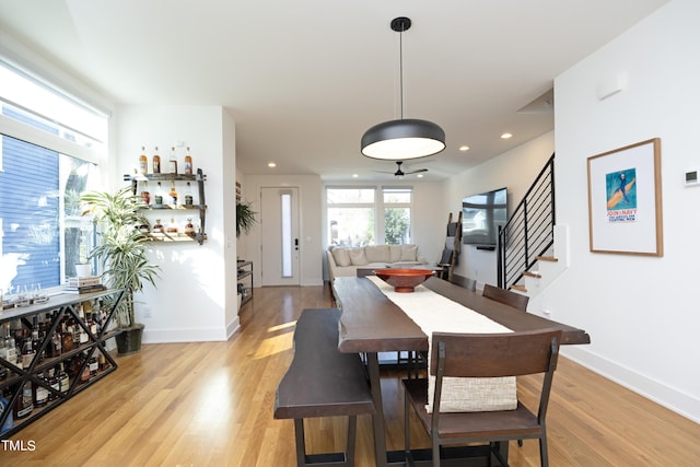 dining space with ceiling fan and light hardwood / wood-style flooring