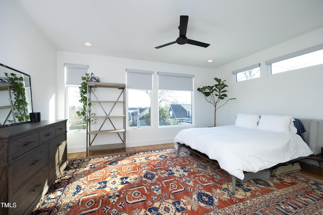 bedroom with ceiling fan, dark hardwood / wood-style floors, and multiple windows