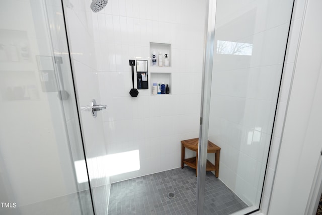 bathroom with a shower with door and tile walls