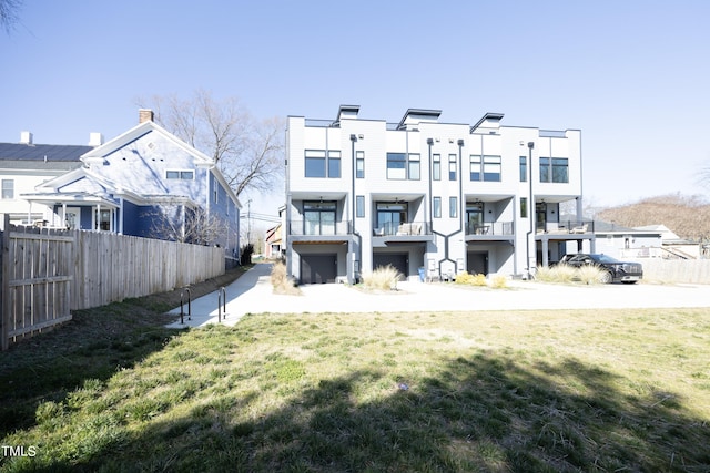 back of house featuring a balcony and a lawn