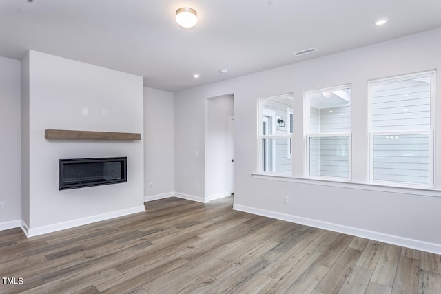 unfurnished living room with a wealth of natural light and hardwood / wood-style floors